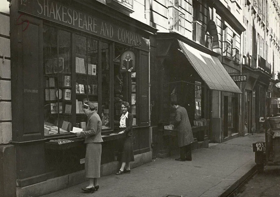 Sylvia Beach standing in front of Shakespeare and Company